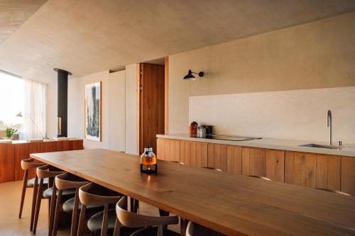 a kitchen with a long wooden table and chairs at Pa.te.os in Melides