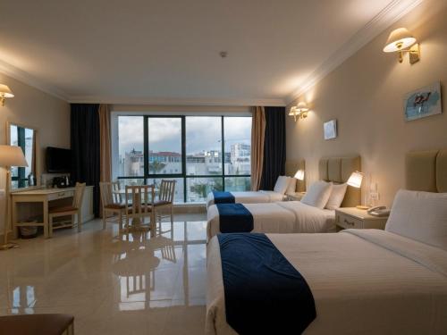 una habitación de hotel con dos camas y una mesa en Amman West Luxury Hotel By Azar, en Amán