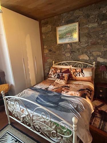 a bed in a room with a stone wall at Alba di Montanaria in Brosso