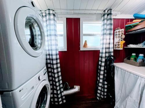 eine Waschmaschine in einer Küche mit roten Wänden in der Unterkunft Stay The Enchanted Escape ! in Castle Hill