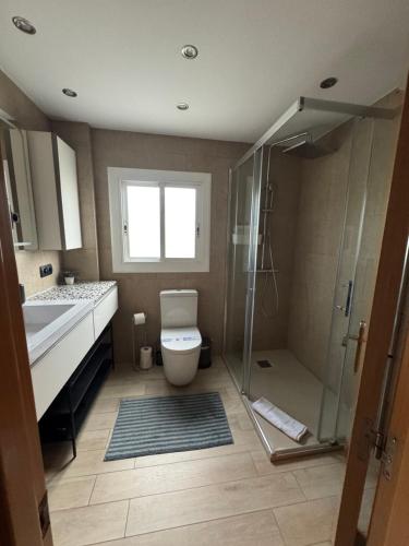 a bathroom with a shower and a toilet and a sink at Ocean View Sunny Beach Apartment Castelldefels in Castelldefels