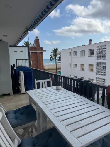 カステルデフェルスにあるOcean View Sunny Beach Apartment Castelldefelsのビーチ付きのバルコニー(テーブル、椅子付)
