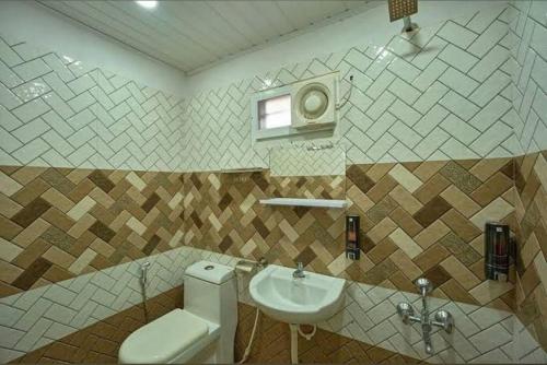 ein Badezimmer mit Toilette und Waschbecken in der Unterkunft The Boho Stays Kochi in Kochi