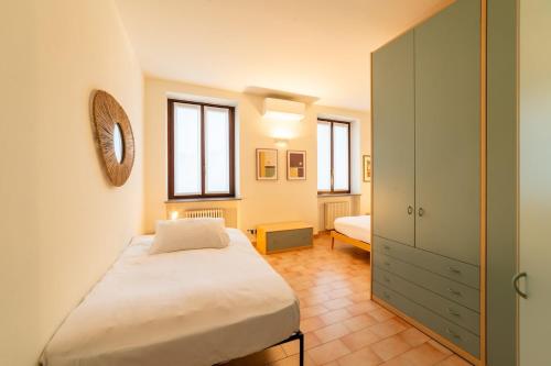 a small bedroom with a bed and a cabinet at Casa Tua Lake Maggiore in Castelletto sopra Ticino