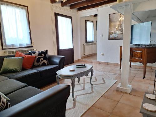 a living room with a couch and a table at Le Clairat in Saint-Michel-Saint-Jaymes