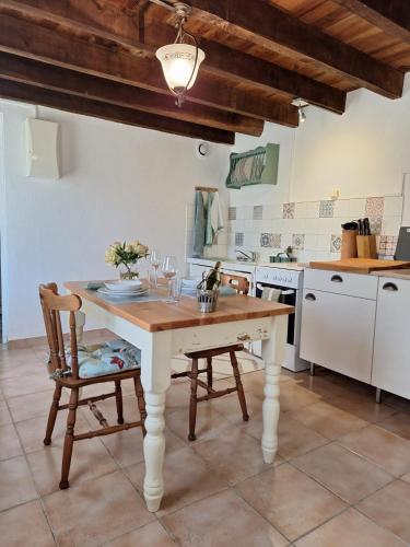 une cuisine avec une table et des chaises dans une pièce dans l'établissement Le Clairat, à Saint-Michel-Saint-Jaymes
