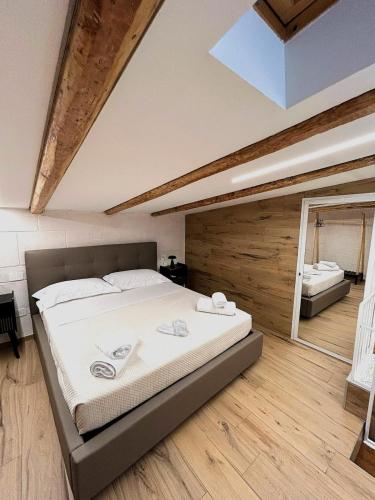 a bedroom with a large bed and a bathroom at Claustro Segreto - ALTAMURA in Altamura