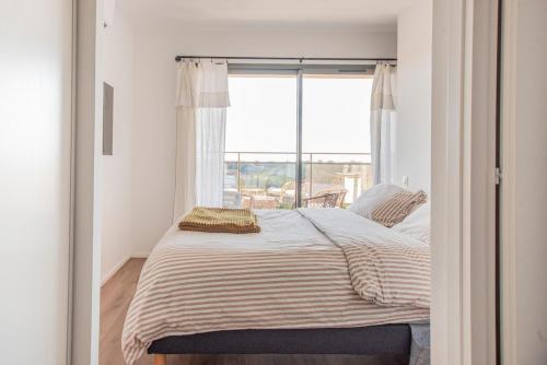 a bedroom with a bed with a large window at 2 bedroom Sun & Terrace with sea view in San-Nicolao
