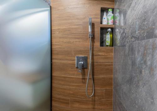 eine Dusche im Bad mit einer Holztür in der Unterkunft Luxury & Modern Apartment - Rowing Canal Plovdiv in Plowdiw