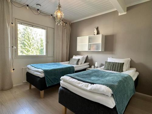 ein Schlafzimmer mit zwei Betten und einem Fenster in der Unterkunft Villa Ateljeerinne in Jyväskylä