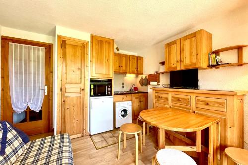 een keuken met houten kasten en een houten tafel en een tafel bij Bright apartment with Mont Blanc view in Combloux