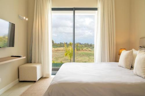 a bedroom with a bed and a large window at Serenity Pool Villa at Azuri in Roches Noires