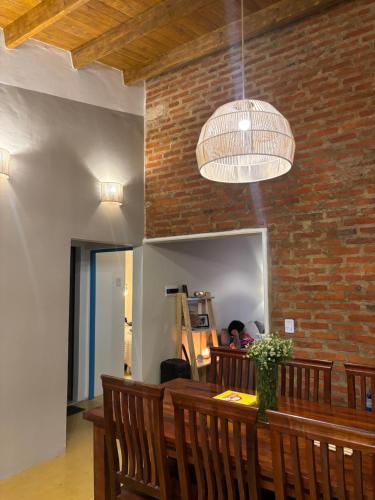 a dining room with a bench and a brick wall at Casa en el Quebrachito in Formosa