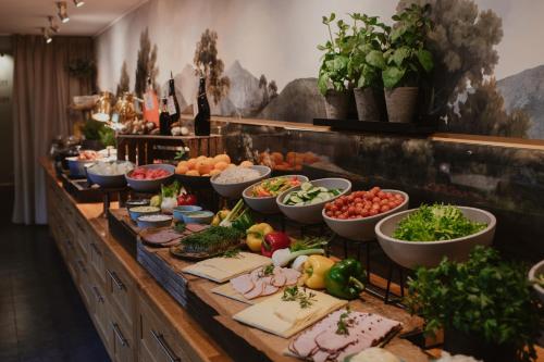 um buffet com muitas tigelas de vegetais e outros alimentos em Home Hotel Drott em Karlstad