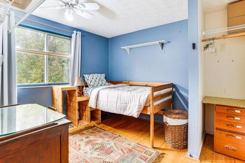a bedroom with blue walls and a bed and a window at Near Trails, Parks and Orchards Germantown Retreat in Germantown