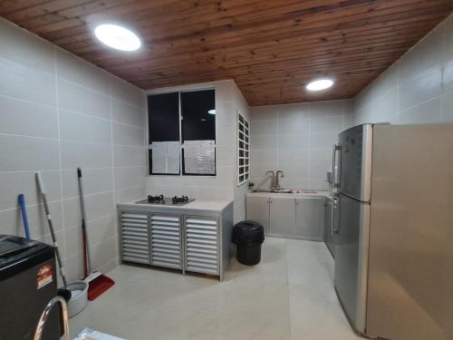 a kitchen with a stainless steel refrigerator and a sink at Lucky 7 Homestay - Utama Court in Sandakan