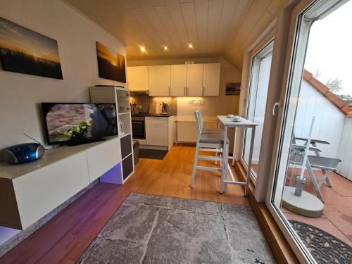 a kitchen with a television and a table with chairs at Meeresfeeling in Horumersiel in Horumersiel