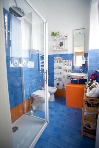 a blue bathroom with a toilet and a shower at Charming and Cozy House in Nettuno