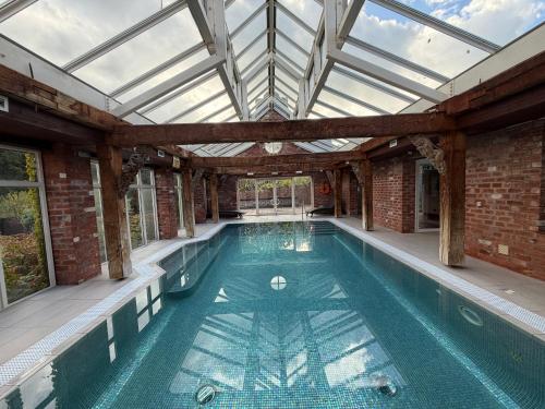 an indoor swimming pool with a glass ceiling at The Gatehouse at Pudleston Court in Hatfield