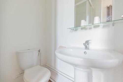 a white bathroom with a sink and a toilet at Hôtel Le Paris Brest in Lens