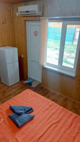 a room with a bed with two blue towels on it at Отель Семейный in Zatoka
