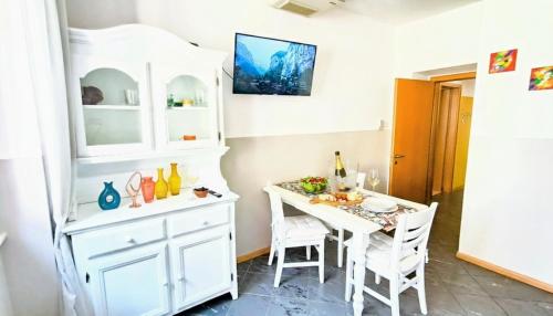 a kitchen with a table and a white cabinet at Strategico tra i MERCATiNi di Natale! zona centro storico - stazione in Trento
