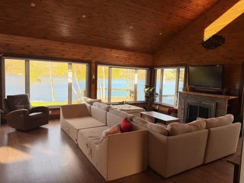 a living room with a white couch and a fireplace at Le Domaine Riverin in Pohénégamook