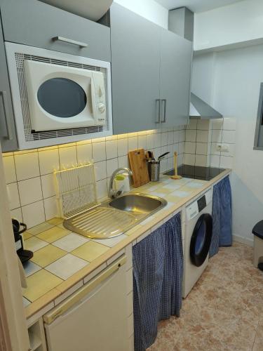 a kitchen with a sink and a microwave at Kalma Casa Luisa in Cazorla