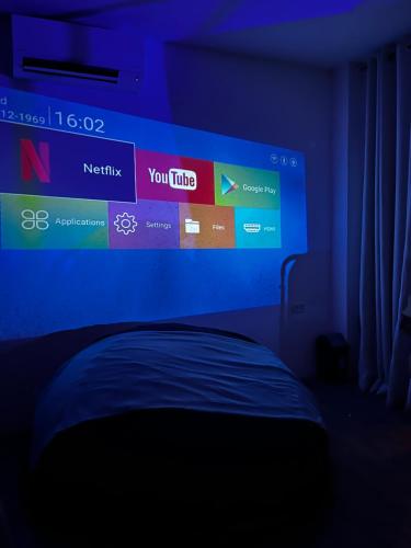 a bedroom with a large screen above a bed at Boxify Cabins 