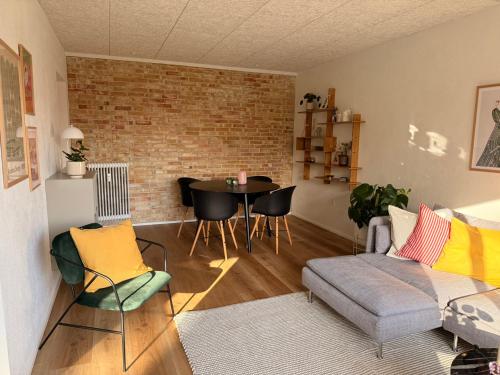 a living room with a couch and a table at Cozy, totally renovated apartment, sleeps 6 in Herning