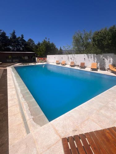 a large swimming pool with blue water and chairs at Apart La Ideal in Villa Cura Brochero