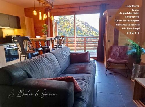Il comprend un salon avec un canapé, une cuisine et une table. dans l'établissement Le Balcon du Snow Roc - Au pied des pistes, magnifique vue sur la vallée - Sauna, à Saint-Jean-dʼAulps