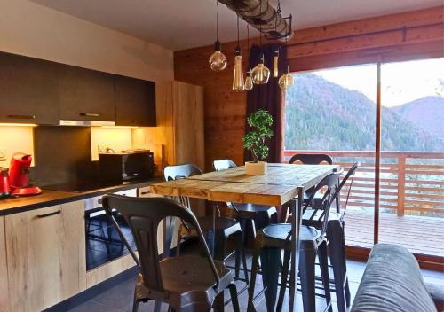 une cuisine et une salle à manger avec une table et des chaises dans l'établissement Le Balcon du Snow Roc - Au pied des pistes, magnifique vue sur la vallée - Sauna, à Saint-Jean-dʼAulps