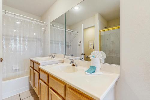 a white bathroom with a sink and a mirror at Barrier Dunes Hideaway in Oak Grove