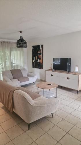 ein Wohnzimmer mit Sofa und Tisch in der Unterkunft Refuge tropical entre mer et nature à Sainte-Rose Guadeloupe in Sainte-Rose