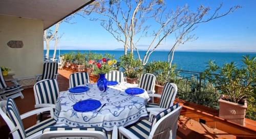 een tafel en stoelen op een balkon met uitzicht op de oceaan bij Argentario Rooms - By The Sea in Porto Santo Stefano