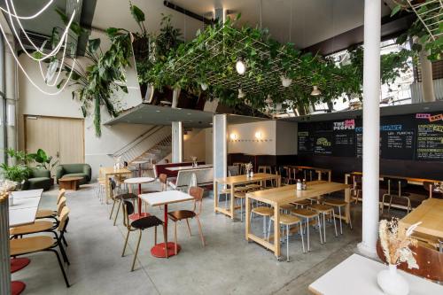 Un restaurante con mesas, sillas y plantas. en The People Lyon, en Lyon