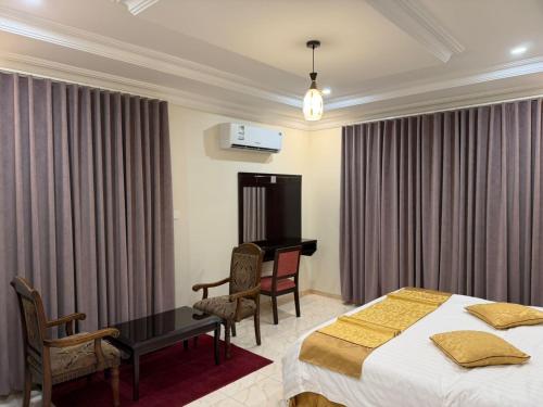 a hotel room with two beds and a desk at شقق الاوفاز للشقق المخدومة--إقتصادي in Qal'at Bishah