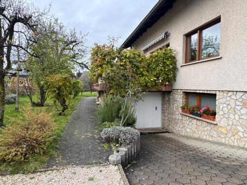 a house with a driveway next to a building at ANMARI Apartment & Rooms in Radovljica