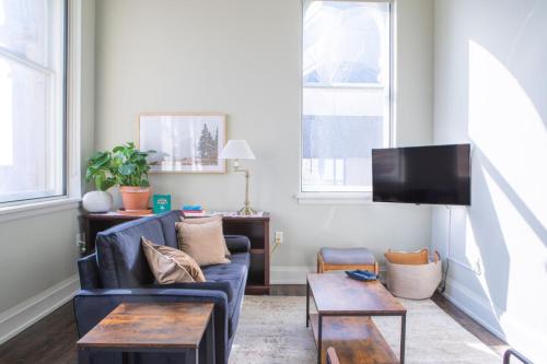 un soggiorno con un divano blu e una TV di Downtown Luxury 1BR Loft a Milwaukee