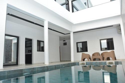 a house with a swimming pool and chairs at Beautiful Modern Villa in Mbour