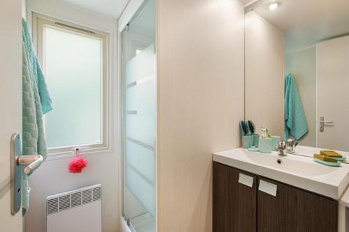 ein Badezimmer mit Waschbecken und Dusche mit Spiegel in der Unterkunft Camping Clicochic Petit Nice in Pyla-sur-Mer