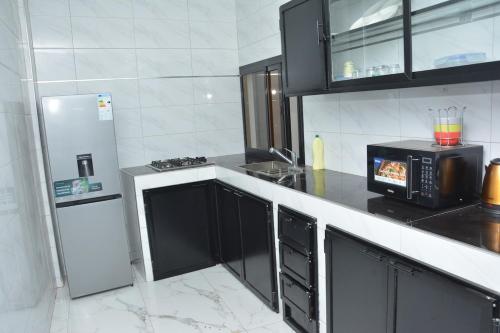 a kitchen with a microwave and a refrigerator at Beautiful Modern Villa in Mbour