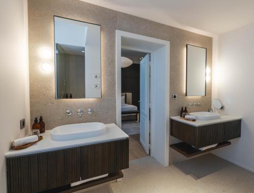 サン・テミリオンにあるLa Villa des Vignesの洗面台が2つと大きな鏡があるバスルーム