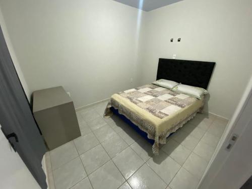 een slaapkamer met een bed in een witte kamer bij AP completo a 5 min da Praia, Itapema-SC in Itapema