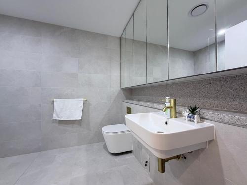 a bathroom with a sink and a toilet and a mirror at Cosy Convenience 2BR APT in Castle Hill in Castle Hill