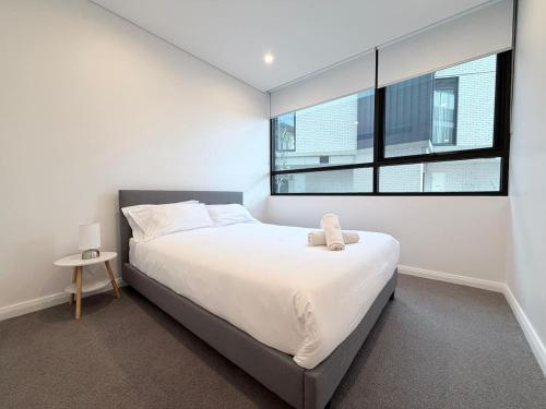 a bedroom with a large bed and a window at Cosy Convenience 2BR APT in Castle Hill in Castle Hill