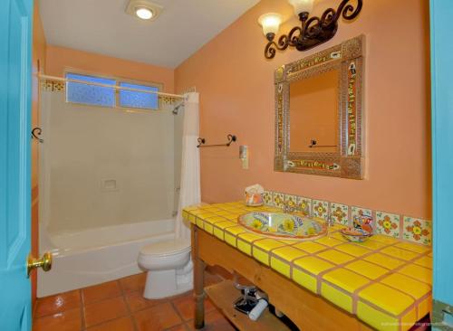 a bathroom with a sink and a toilet and a mirror at Adobe Hacienda- Dreamcatcher Suite in Oak Creek