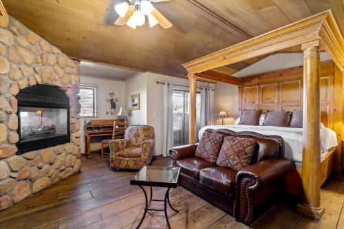 a bedroom with a bed and a stone fireplace at Adobe Village Studio Suite- Sundance in Oak Creek