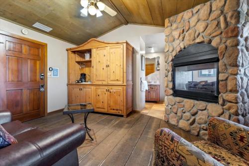 a living room with a stone fireplace and a television at Adobe Village Inn Sundance Suite in Sedona